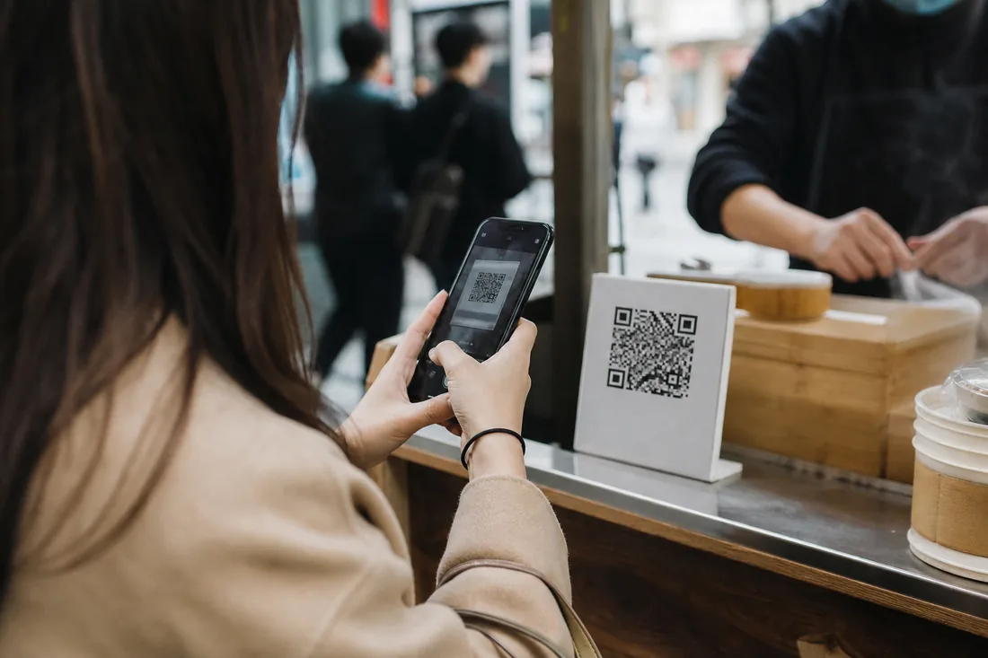 A customer paying by scanning a QR code with a phone at a street stall in China
