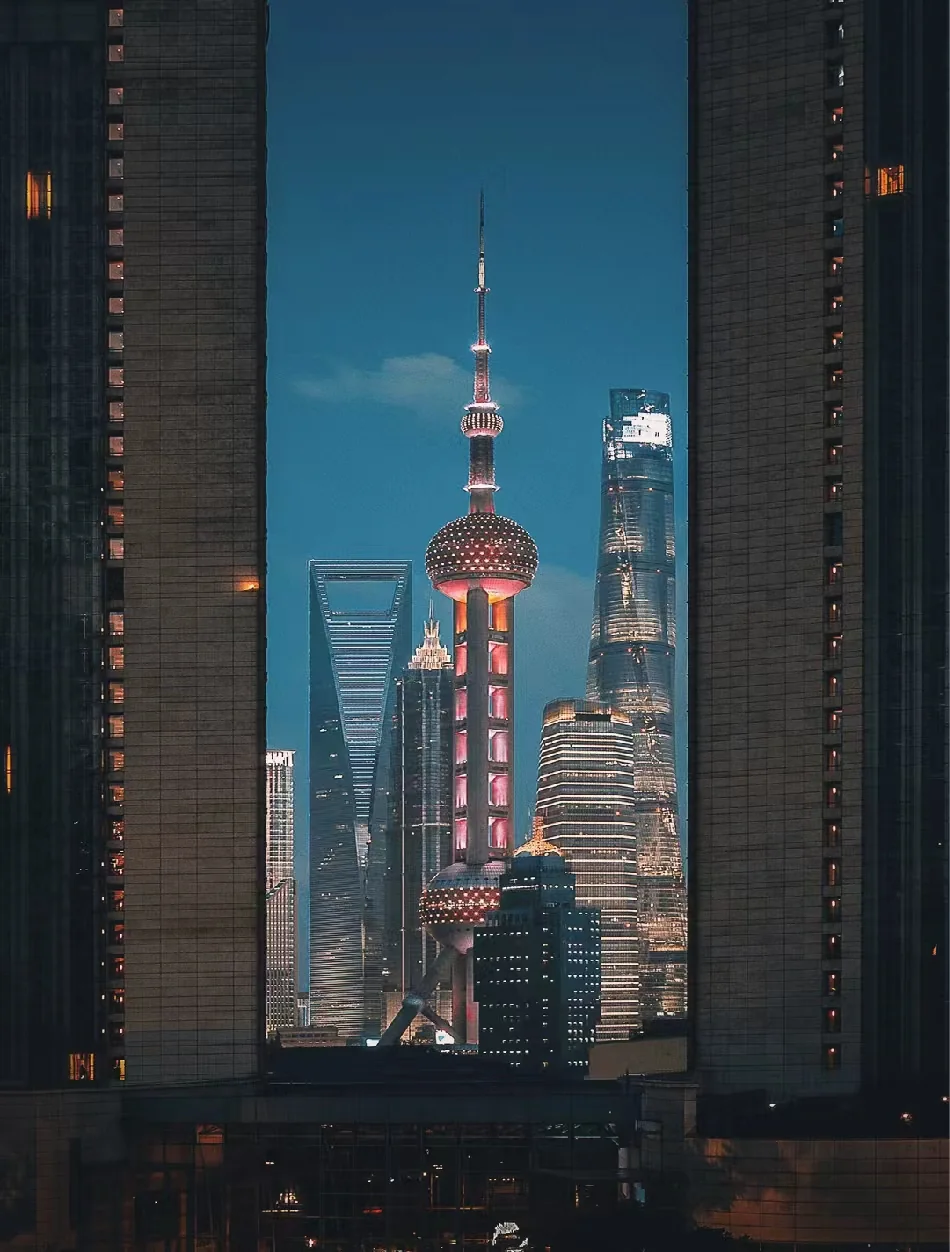 The illuminated towers of Shanghai's Pudong skyline framed at dusk
