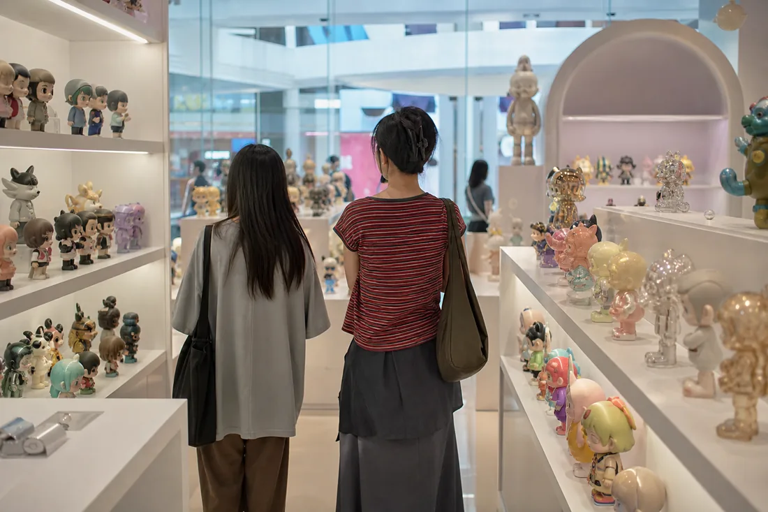 A bright modern designer toy store with shelves of collectible figures in a Chinese mall