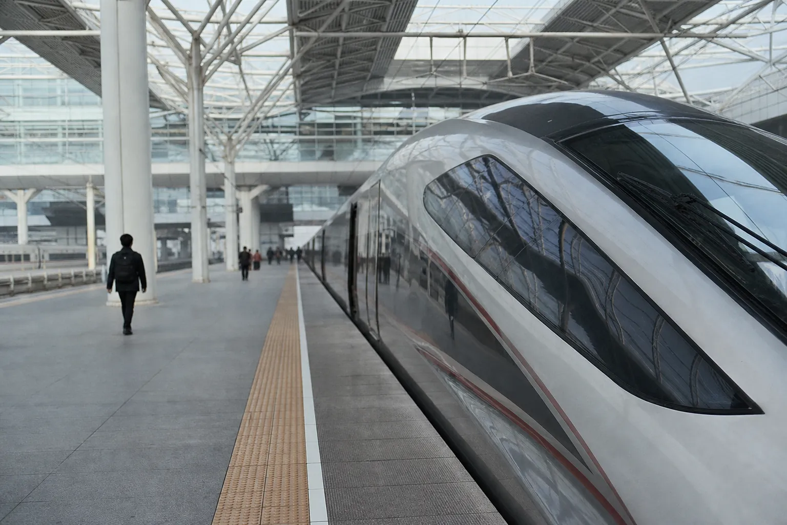 A sleek high-speed train waiting at a calm, modern Chinese station platform